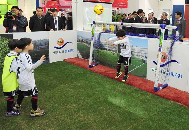 필드터프 잔디에서 축구 시합하는 어린이들