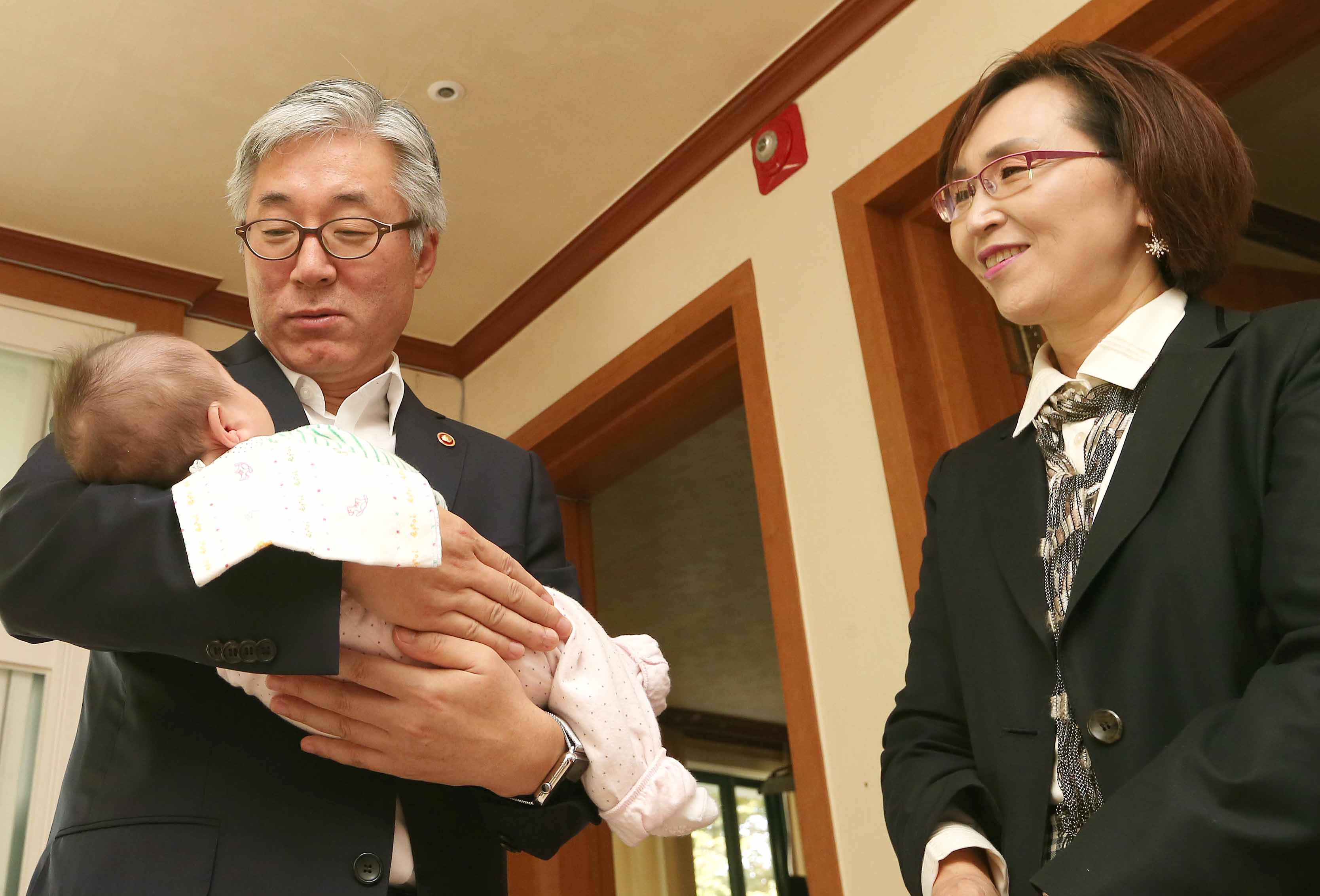 김종덕 문화체육관광부 장관이 보육원에서 일시 보호 상태인 영아를 따뜻하게 안아주고 있다