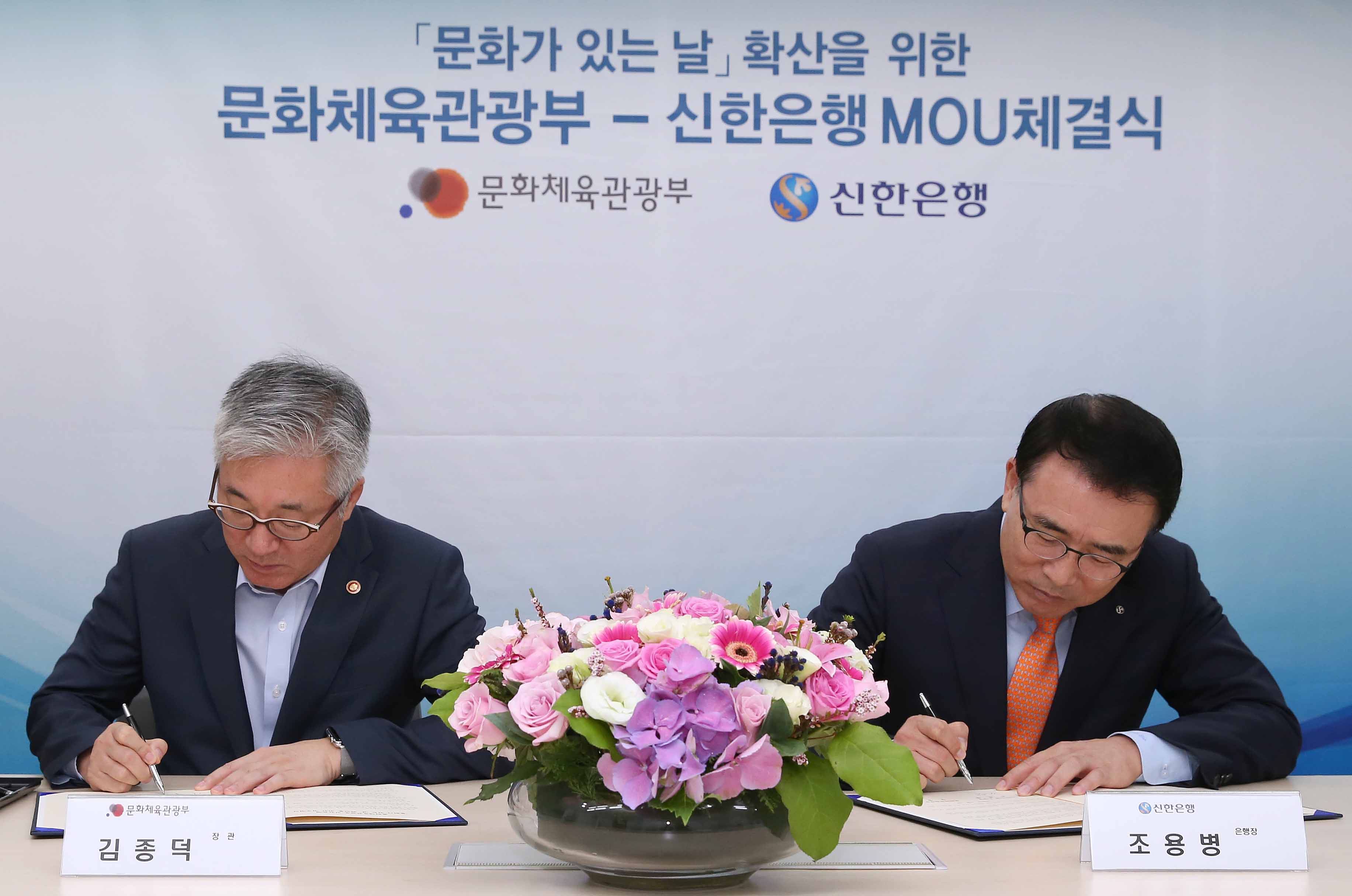 김종덕 문화체육관광부 장관(좌)과 조용병 신한은행장(우)이 업무협약서에 서명을 하고 있다.